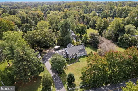 an aerial view of residential house with outdoor space and trees all around