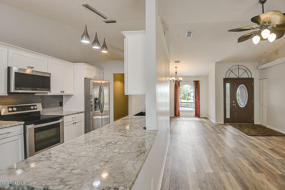 115 Beechwood Road St. Augustine, FL 32086 - Photo 5 of 28 a large kitchen with cabinets stainless steel appliances a stove and a center island