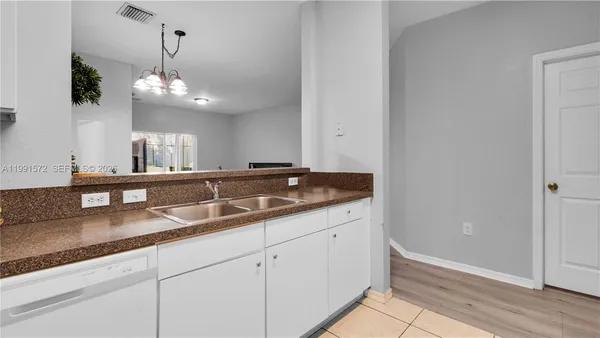 a view of a kitchen with granite countertop stainless steel appliances sink and wooden floor
