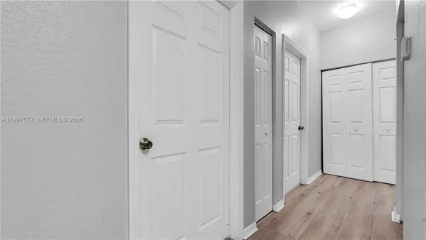 a view of a hallway with wooden floor