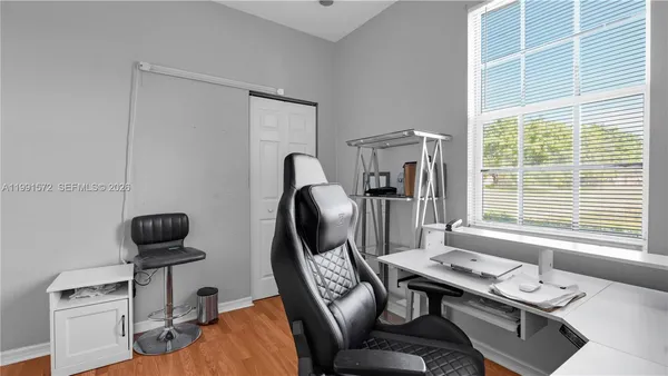 a view of a workspace with furniture and a window