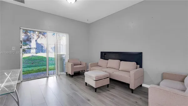a living room with furniture and a wooden floor