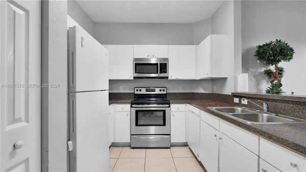 a kitchen with granite countertop a sink and a stove top oven
