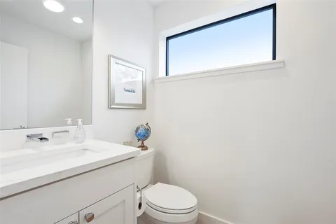 a bathroom with a sink mirror and toilet