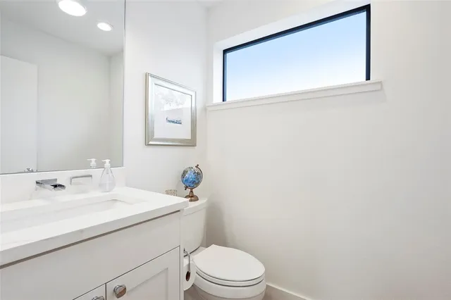 a bathroom with a sink mirror and toilet