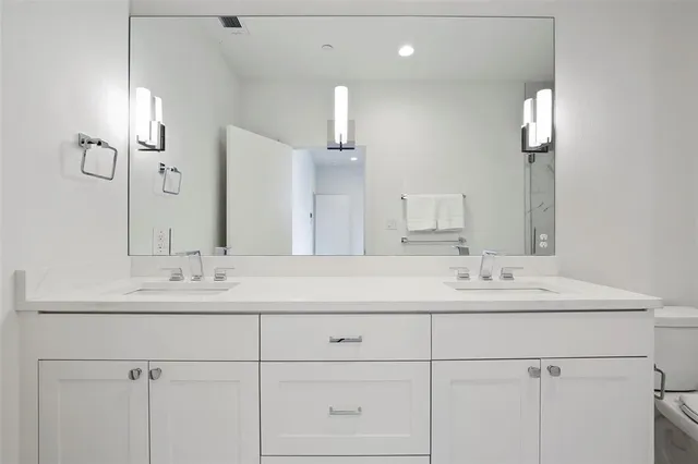 a bathroom with double sink and a mirror