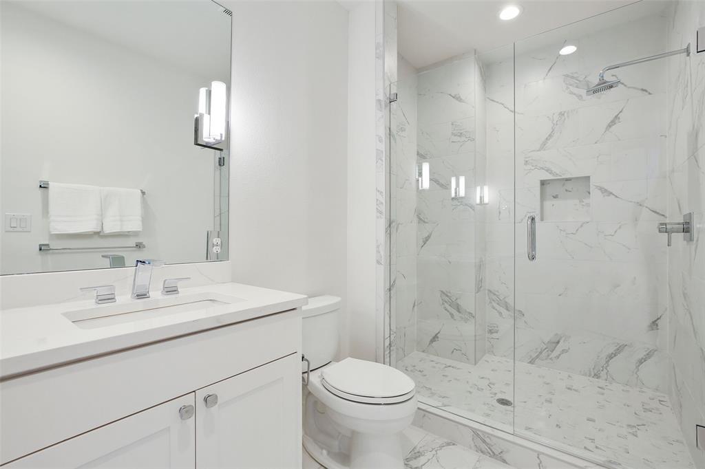 2307 Kirby Street, Unit B Dallas, TX 75204 - Photo 20 of 28 a bathroom with a sink toilet a mirror and shower