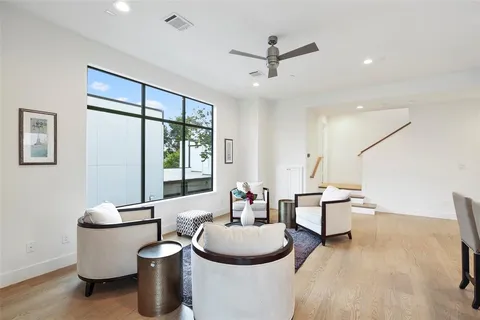 a living room with furniture a window and a ceiling fan