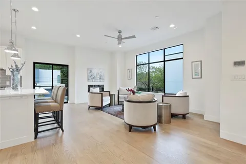 a living room with furniture a large window and wooden floor