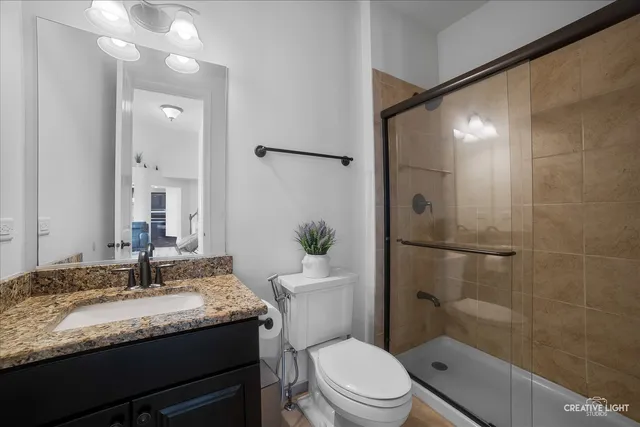 a bathroom with a granite countertop sink toilet and shower