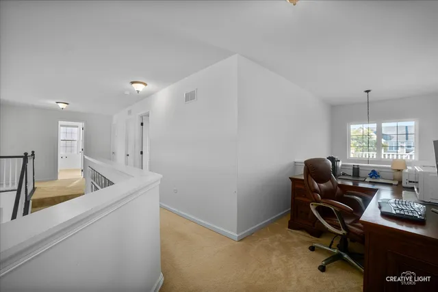 a view of a workspace with furniture and a window