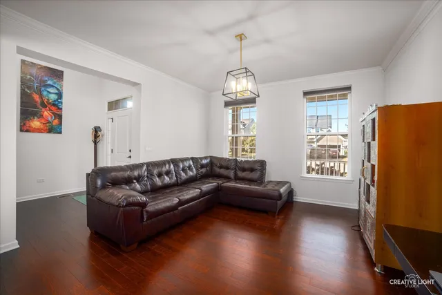 a living room with couches and a dining table with wooden floor