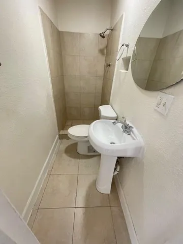 a bathroom with a sink toilet and mirror