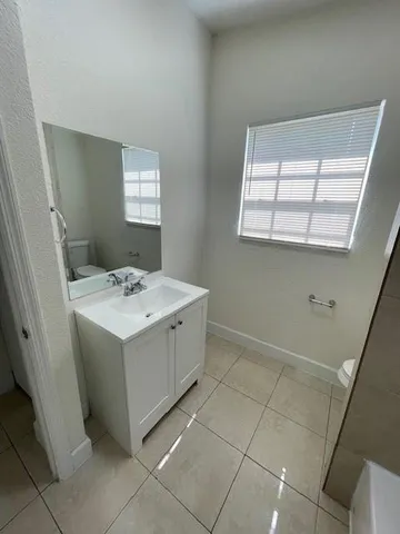 a utility room with a sink a window and washer