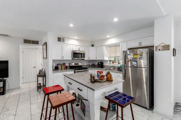 a kitchen with stainless steel appliances a refrigerator and a stove top oven
