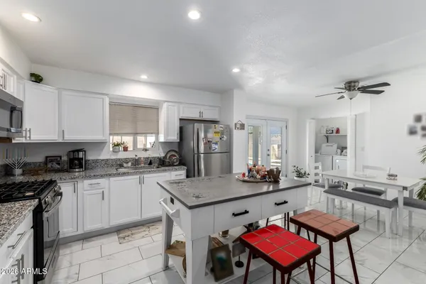 a kitchen with a dining table chairs and refrigerator
