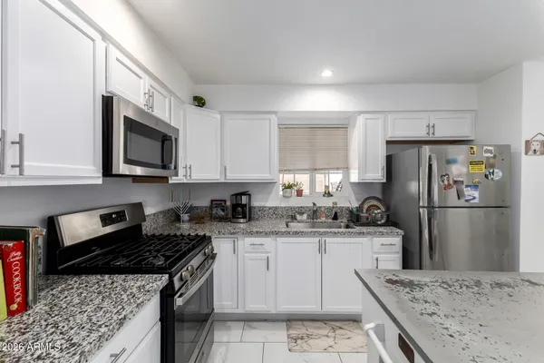 a kitchen with a sink a refrigerator a microwave and cabinets