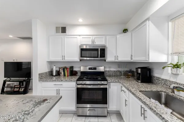 a kitchen with granite countertop a stove and a sink