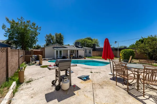a view of backyard with swimming pool and furniture