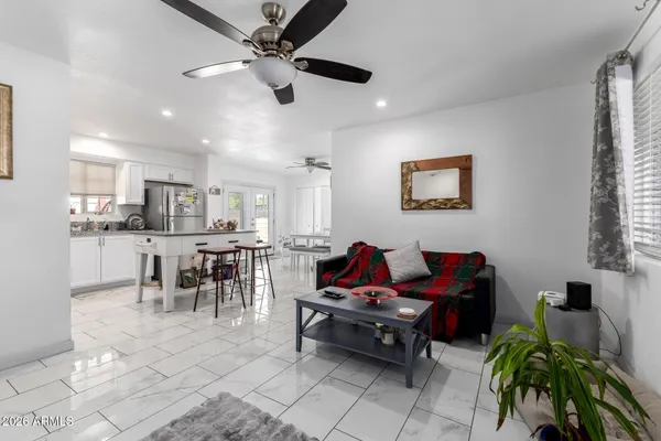 a living room with furniture kitchen view and a window