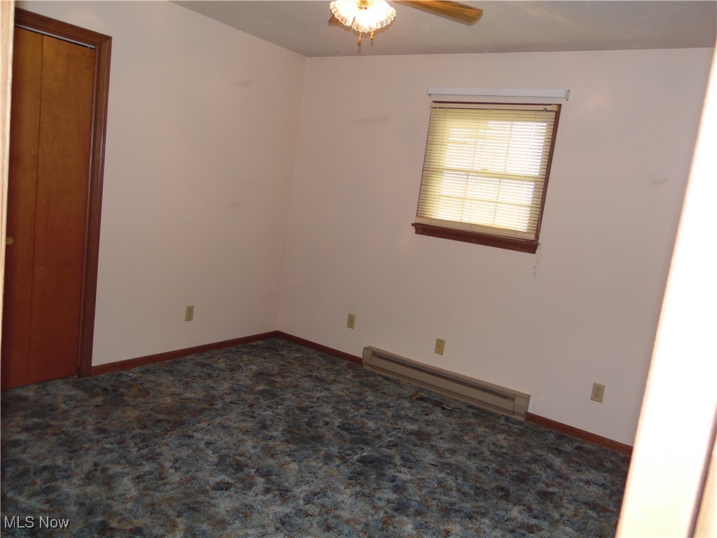 2800 Tick Ridge Road Lower Salem, OH 45745 - Photo 12 of 28 Spare room featuring baseboards, a ceiling fan, a baseboard heating unit, and carpet