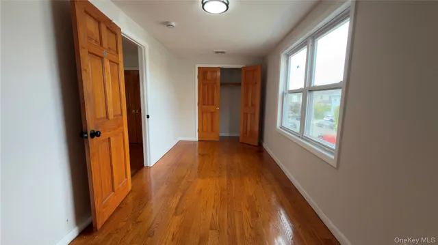 a view of hallway with windows and wooden floor