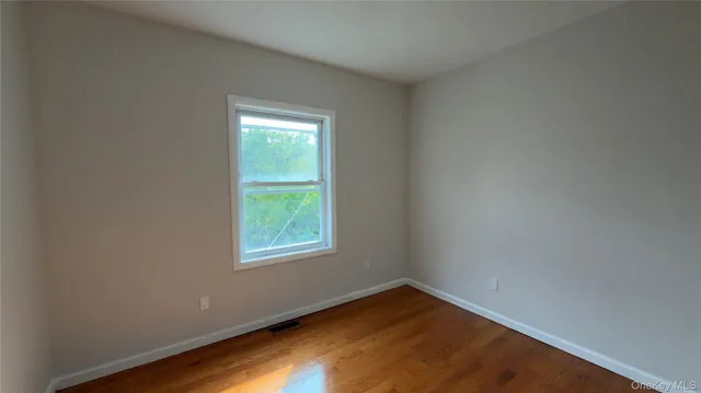 a view of a room with wooden floor and windows