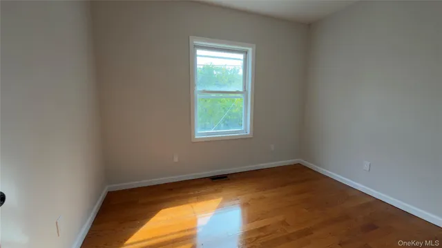 a view of a room with wooden floor and window