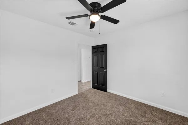 an empty room with closet and fan