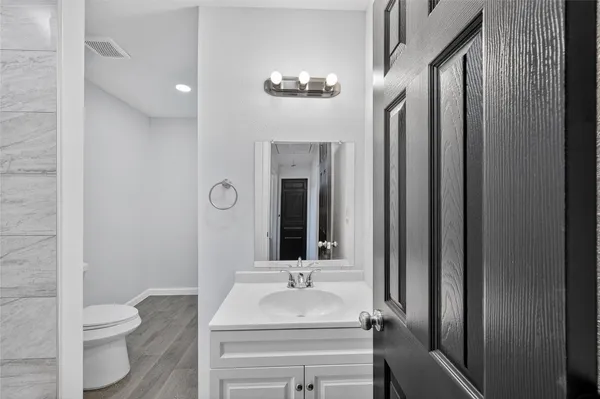 a bathroom with a sink vanity mirror and toilet