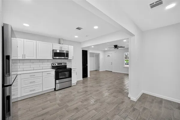 a kitchen with white cabinets and stainless steel appliances