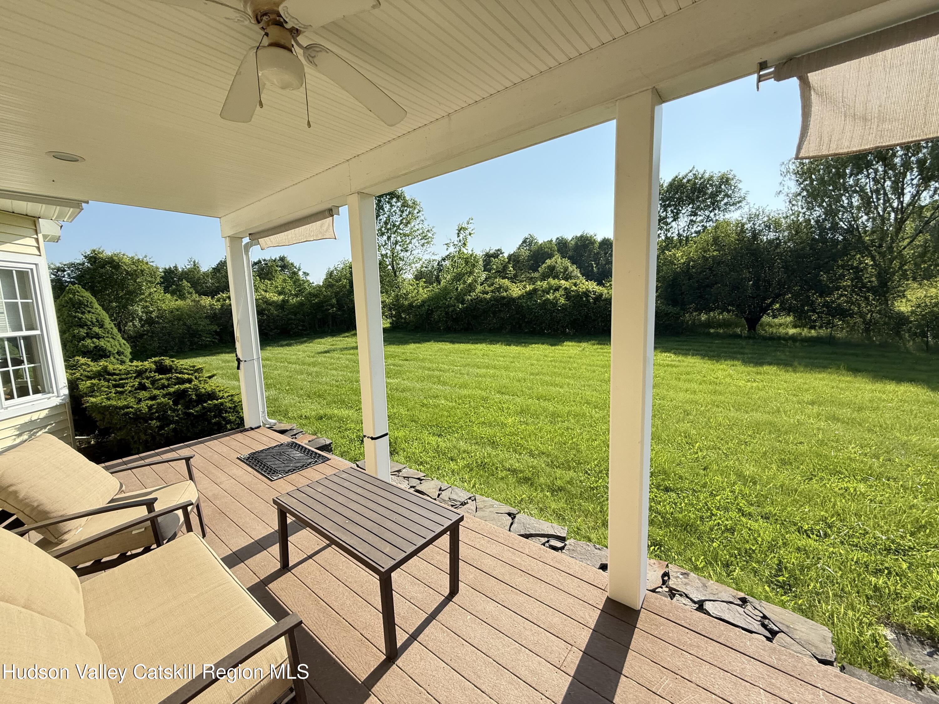 2914 Sleepy Hollow Road Athens, NY 12015 - Photo 6 of 39 a view of a patio with lawn chairs floor to ceiling window next to a yard