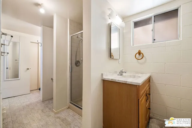 a bathroom with a sink and mirror with shower