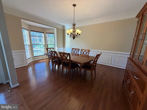 a dining room with furniture wooden floor and a chandelier