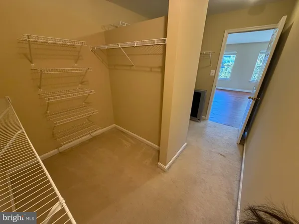 a view of an empty room with wooden floor and window