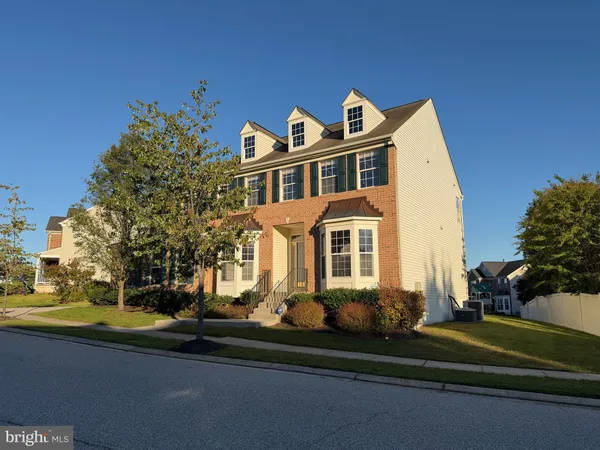 a front view of a house with a yard and potted plants