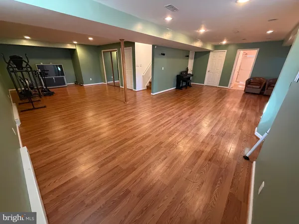 a view of a livingroom with wooden floor and furniture
