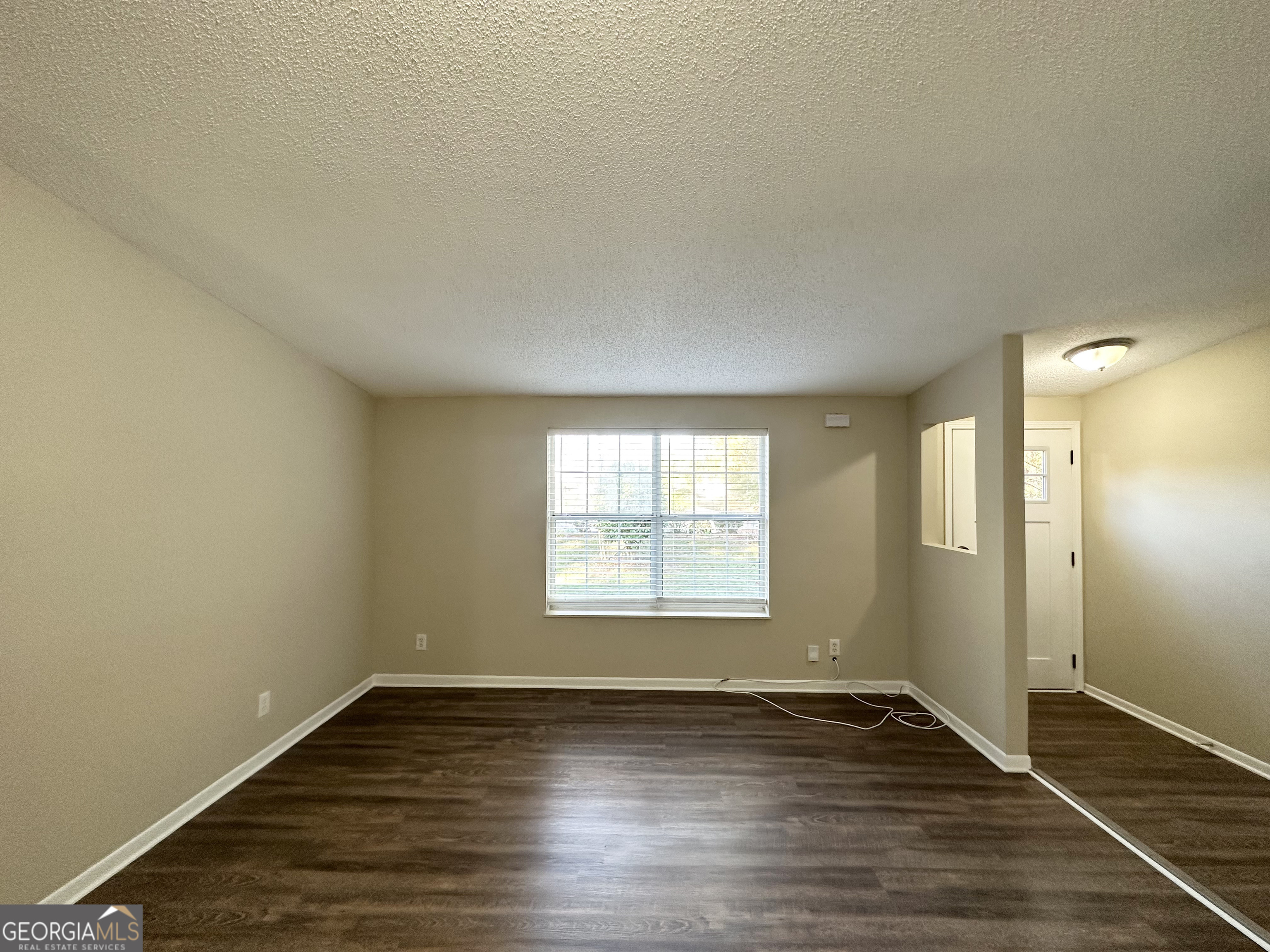 7125 Rhodes Street Lithonia, GA 30058 - Photo 15 of 30 an empty room with wooden floor and windows