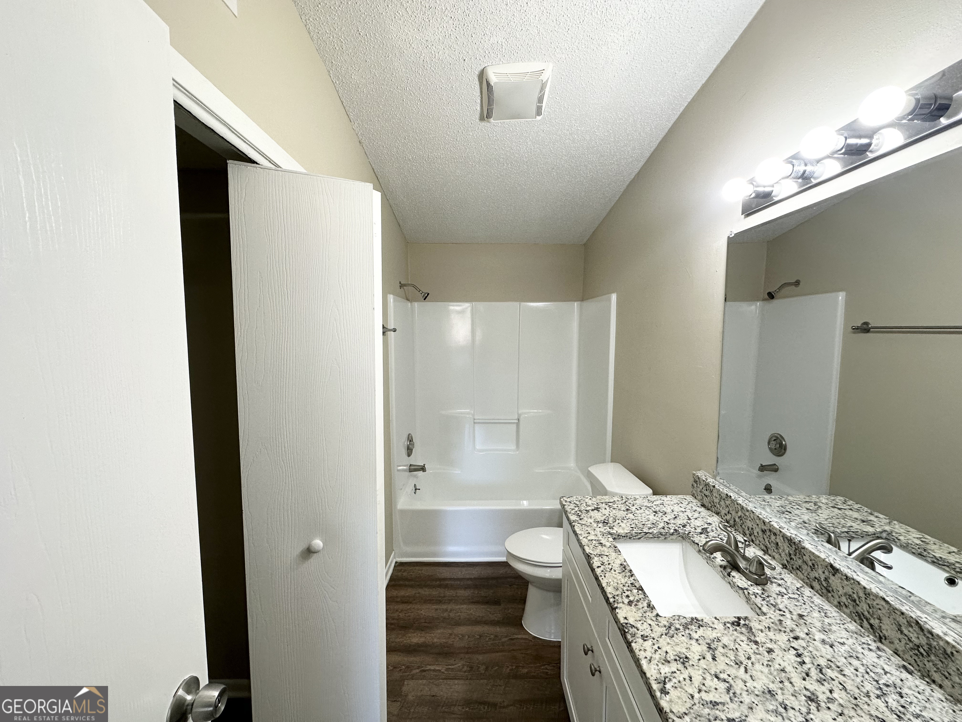 7125 Rhodes Street Lithonia, GA 30058 - Photo 26 of 30 a bathroom with a granite countertop sink a toilet and shower
