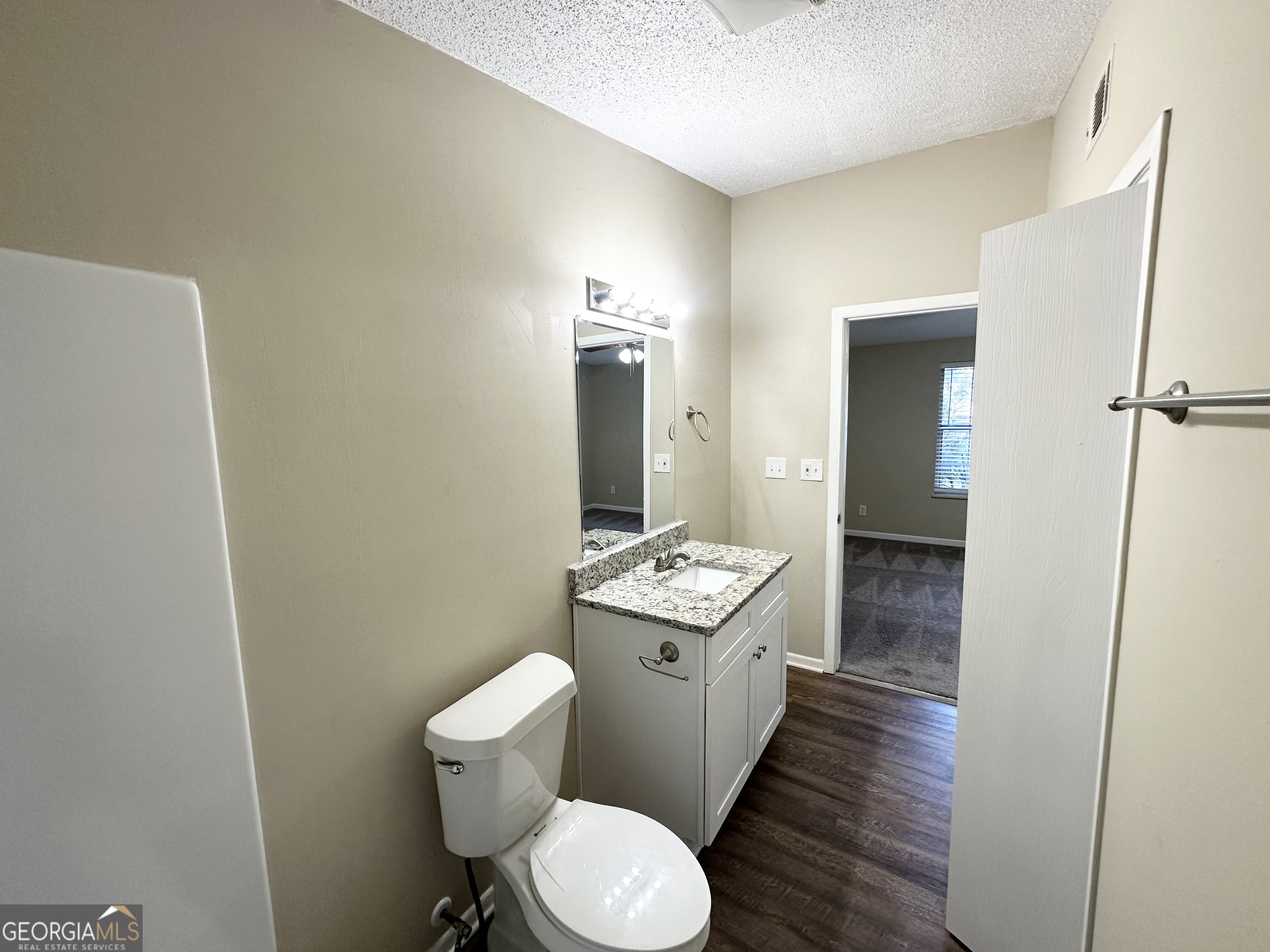 7125 Rhodes Street Lithonia, GA 30058 - Photo 28 of 30 a bathroom with a granite countertop toilet sink and a mirror