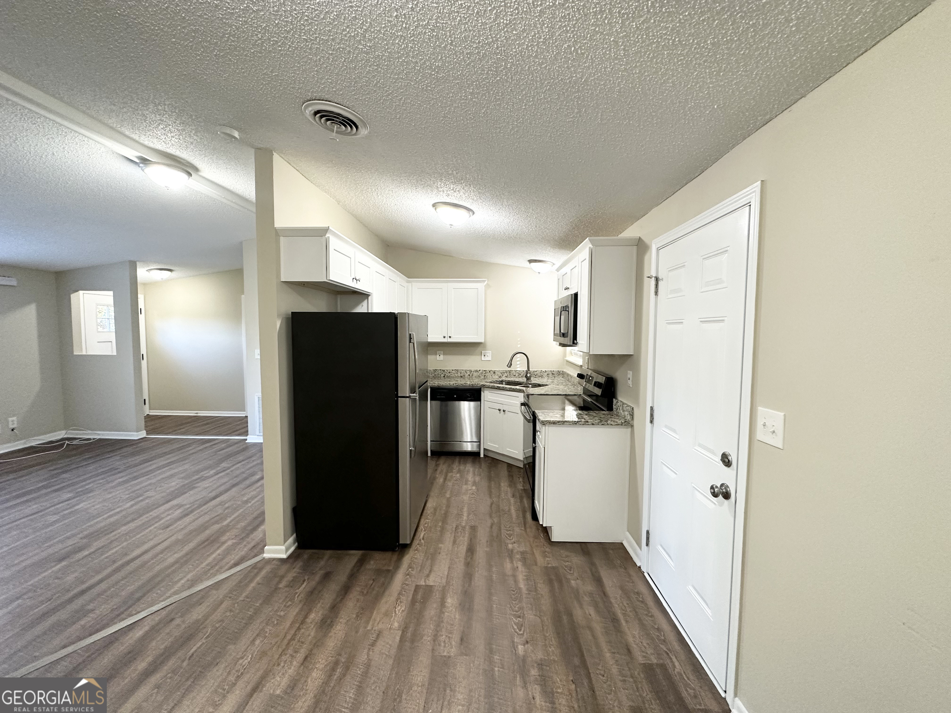 7125 Rhodes Street Lithonia, GA 30058 - Photo 6 of 30 a view of a kitchen with a refrigerator and a stove top oven