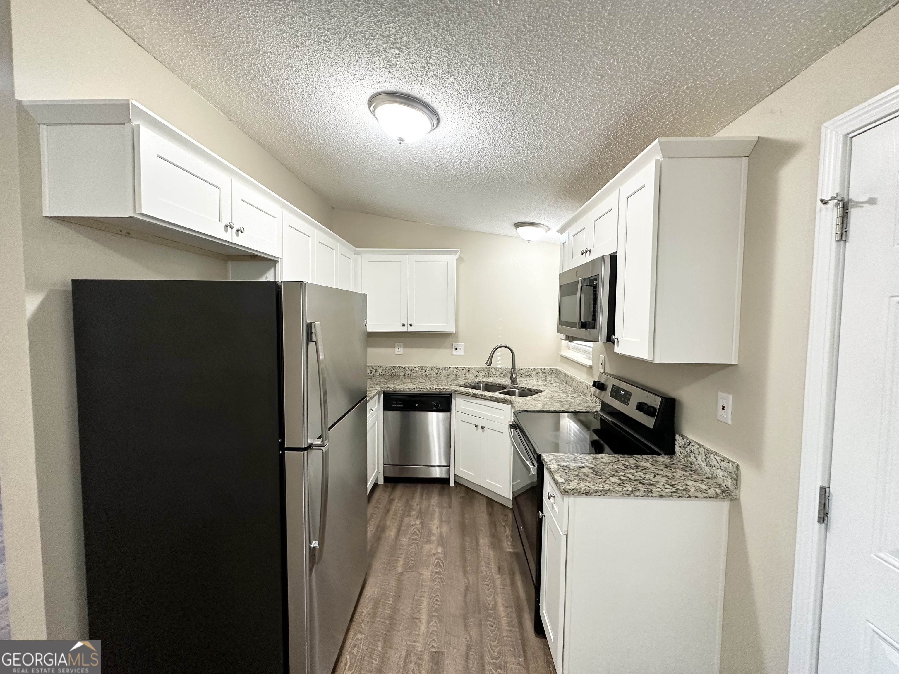 7125 Rhodes Street Lithonia, GA 30058 - Photo 7 of 30 a kitchen with a refrigerator stove microwave and sink