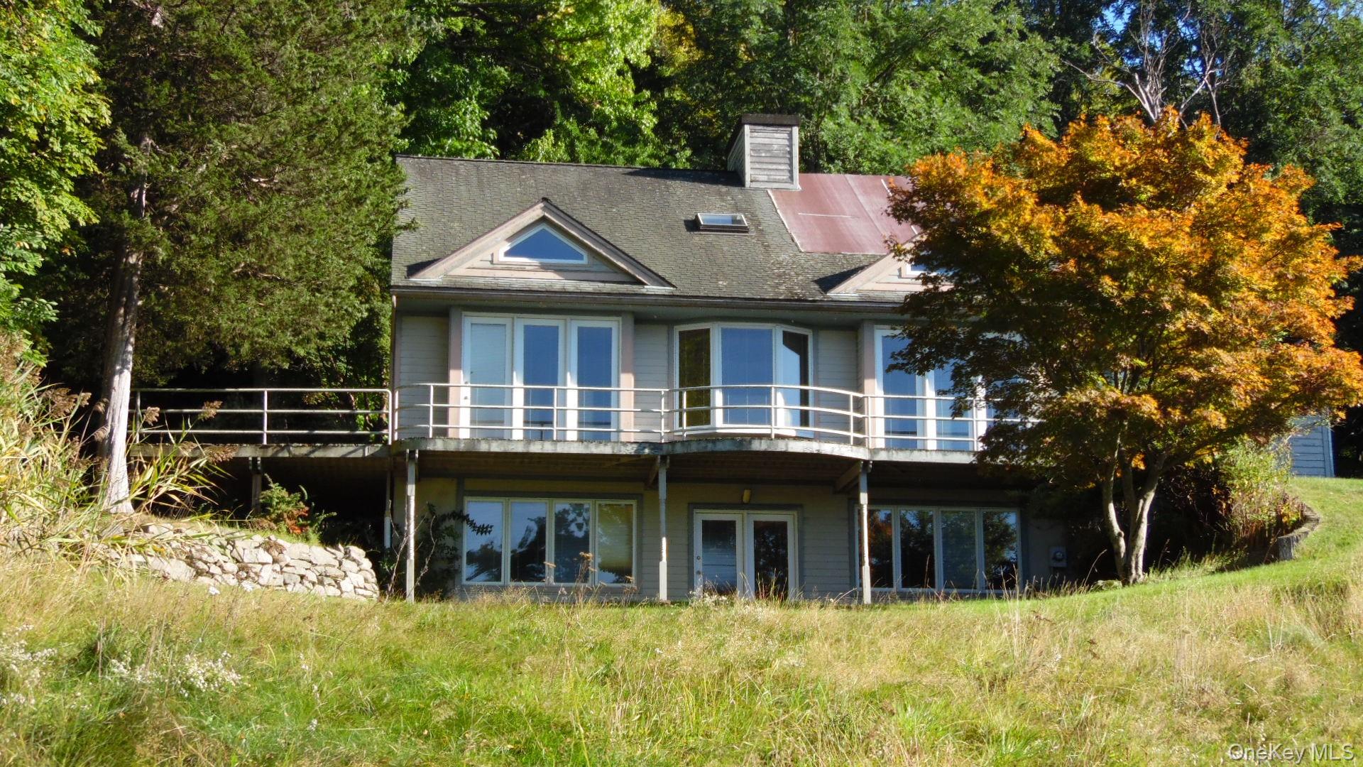 5 Eagle Head Road Cornwall-on-Hudson, NY 12520 - Photo 20 of 24 Back of house with walls of windows to allow natural light and expansive views of the mountains and valley below.
