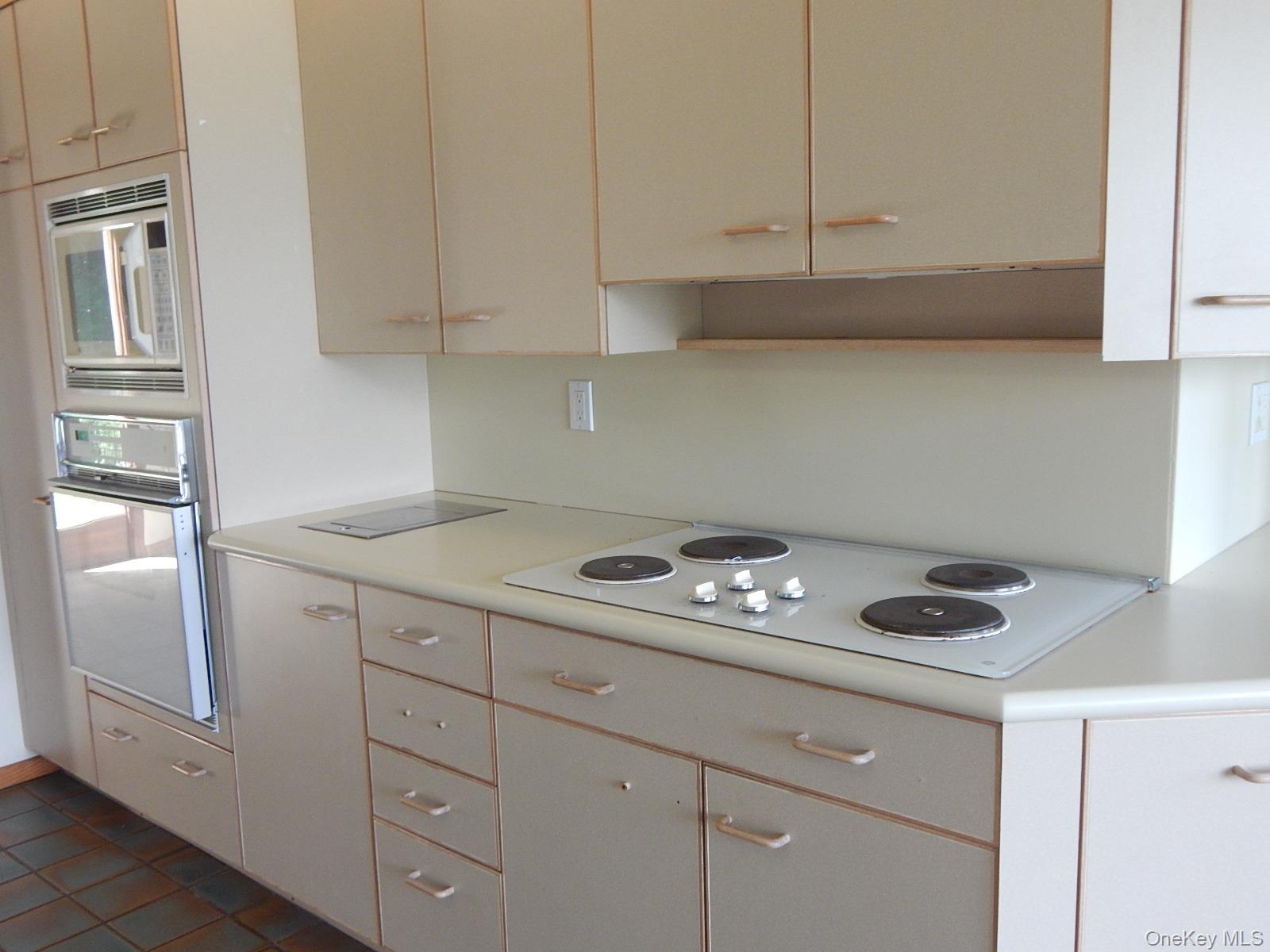 5 Eagle Head Road Cornwall-on-Hudson, NY 12520 - Photo 4 of 24 Kitchen with light countertops, white appliances, glass insert cabinets, and dark tile patterned flooring