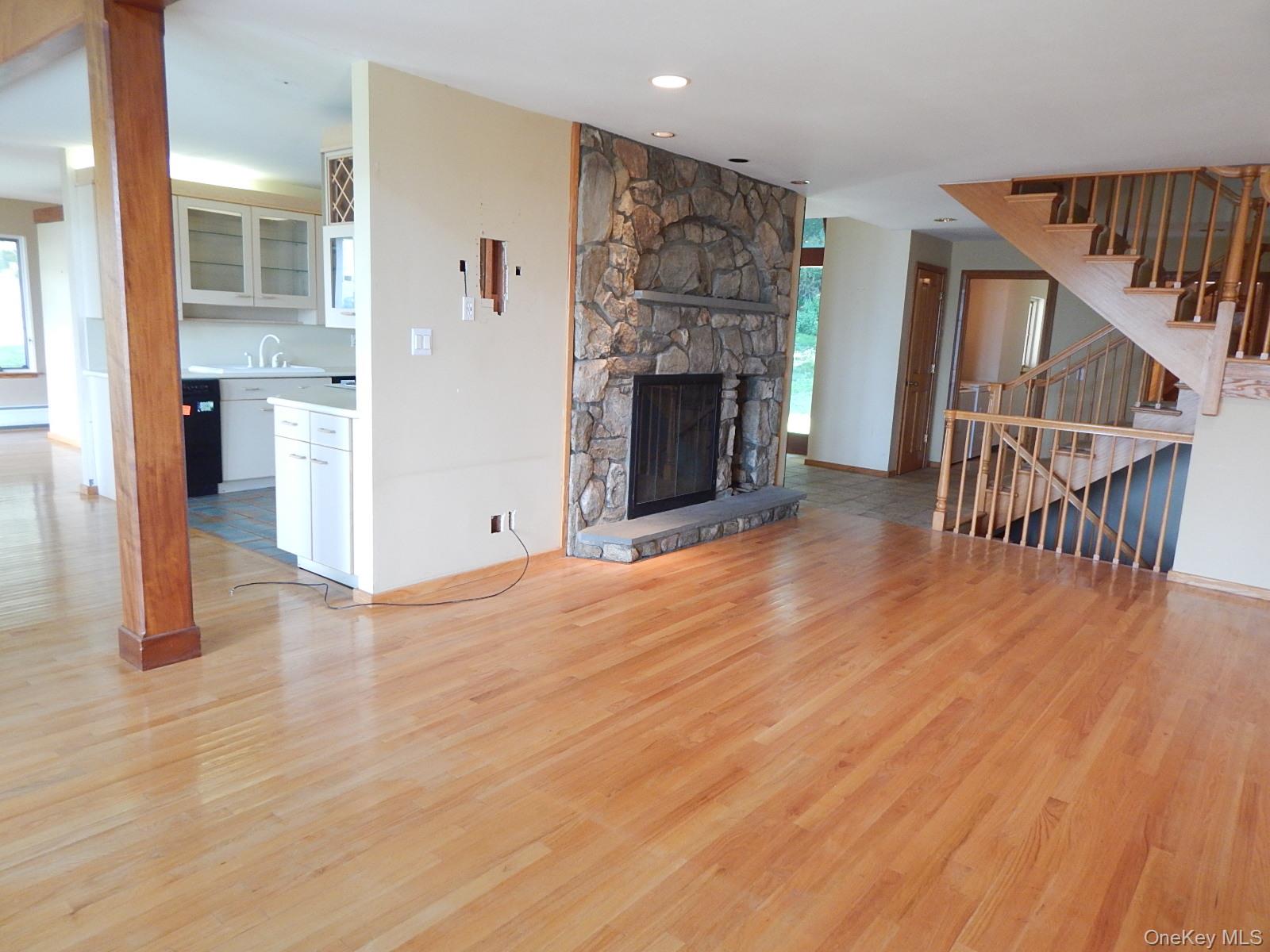 5 Eagle Head Road Cornwall-on-Hudson, NY 12520 - Photo 6 of 24 Unfurnished living room featuring a stone fireplace, light wood finished floors, recessed lighting, and a baseboard heating unit