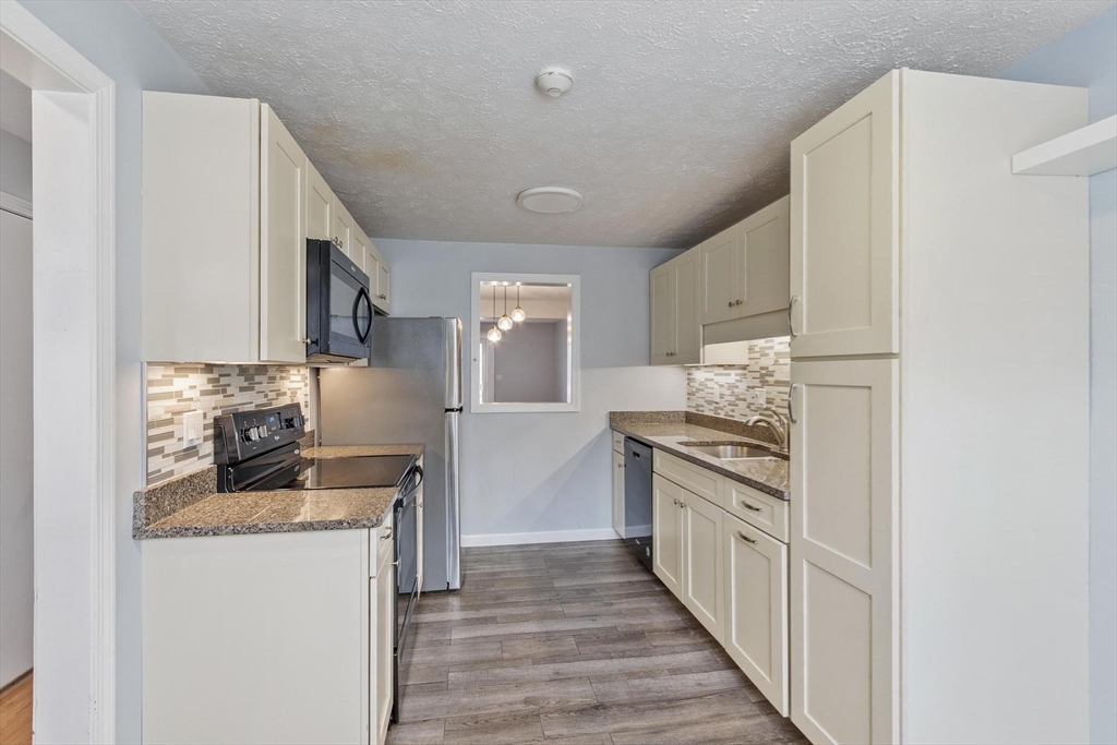 48 Fox Meadow Road, Unit F Leominster, MA 01453 - Photo 2 of 36 a kitchen with granite countertop a sink and a stove top oven