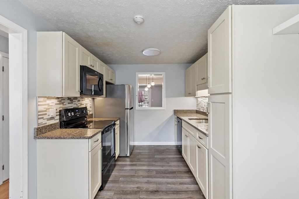 48 Fox Meadow Road, Unit F Leominster, MA 01453 - Photo 3 of 36 a kitchen with granite countertop a stove top oven and sink