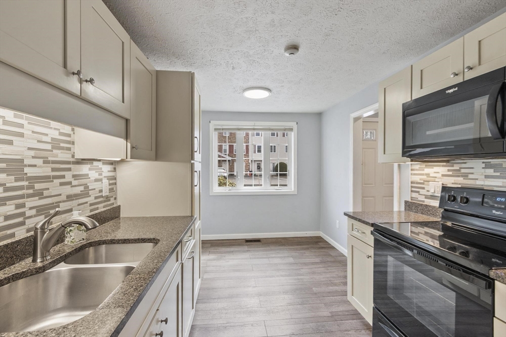 48 Fox Meadow Road, Unit F Leominster, MA 01453 - Photo 5 of 36 a kitchen with granite countertop a sink stainless steel appliances and cabinets