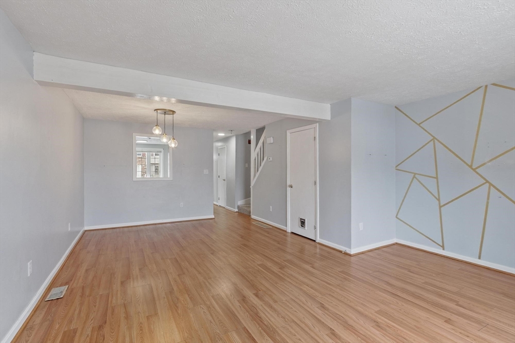 48 Fox Meadow Road, Unit F Leominster, MA 01453 - Photo 7 of 36 an empty room with wooden floor and windows