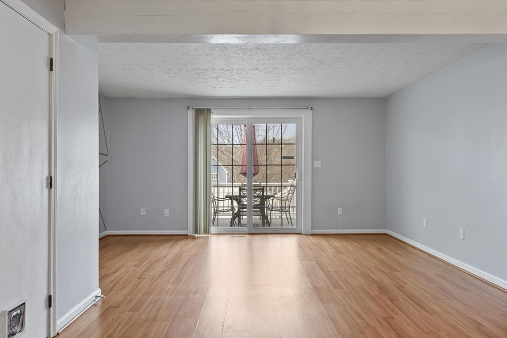 48 Fox Meadow Road, Unit F Leominster, MA 01453 - Photo 10 of 36 an empty room with wooden floor and windows
